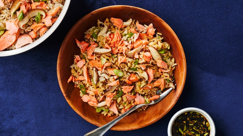 Salmon shiitake mushrooms green onions and rice in a bowl.